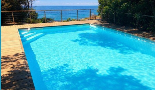 Seafront with direct beach access and private heated pool in a green setting